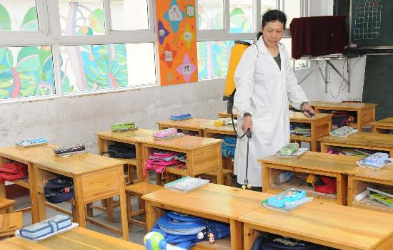 图文:湖北宜昌小学校医在教室内喷洒消毒液