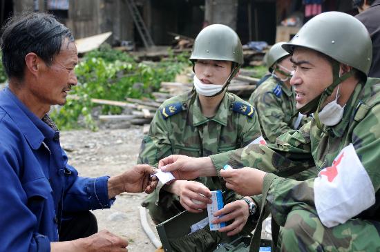 图文:空降兵突击队队员向灾民分发药品