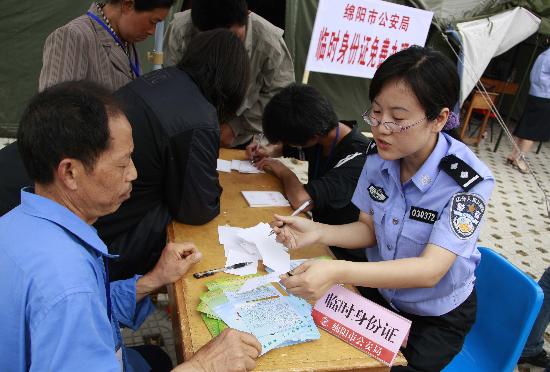 图文:一位民警正指导受灾群众办理临时身份证