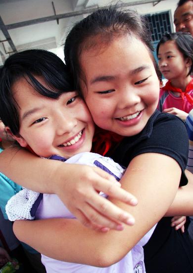 图文:灾区2个孩子异地重逢高兴地拥抱在一起