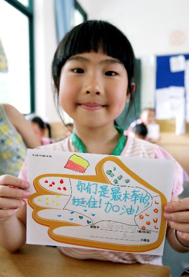 图文:小学生展示自己写给灾区小伙伴的祝愿卡