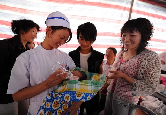 图文:妇产科护士在为灾区新生儿喂奶
