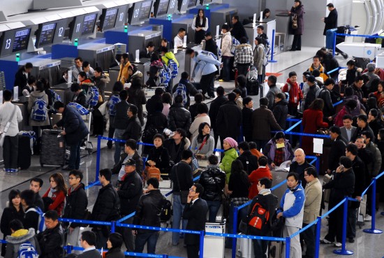 图文:乘客在上海浦东机场排队办理登机手续