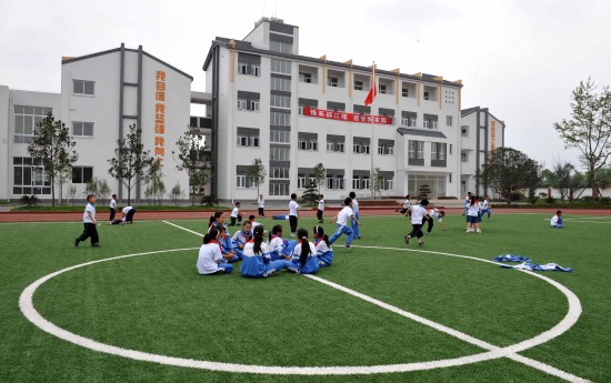 图文:孩子们在新校舍的操场上体育课