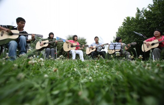 图文:刘敏和轮椅吉他队成员在练习演唱歌曲