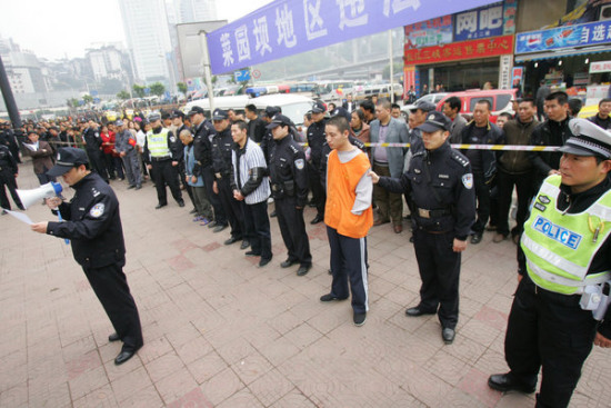 组图：重庆警方押解15名犯罪嫌疑人指认现场