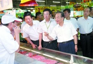 7月9日，温家宝来到咸阳华润万家超市了解猪肉供应销售情况。新华社发