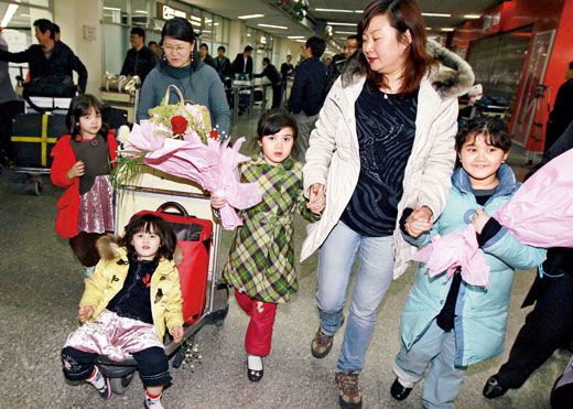 3月5日晚11时许，从利比亚归来的张春艳（左后）和她的4个孩子走出上海虹桥机场。北京时间3月5日晚11时15分，中国政府协调派出的上海航空公司包机FM608航班抵达上海虹桥机场，从马耳他接回最后一批从利比亚撤出的中国人员149人。至此，中国撤离在利比亚人员行动圆满结束，共撤出35860人，已全部回国