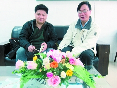 　　图为肖传国(右)在接受本报记者采访