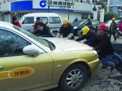 马路上留堆沥青“忘运走” 粘死出租车底盘