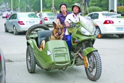 摩托的男子行驶在长江路上,这辆三轮车的驾驶员身穿八十年代白色款的