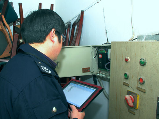 环境执法人员利用IPAD移动执法平台，现场查询酒店油烟净化器实时运行状态并进行比对。晏利扬摄