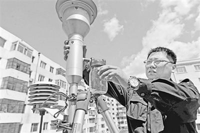 哈尔滨环境监测站的工作人员正在维护PM2.5空气收集器（资料图片）