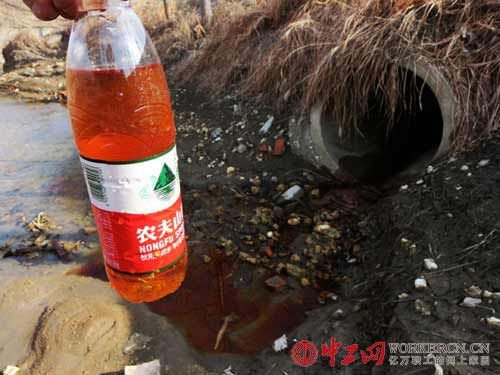 在马姚闸桥西侧，通向化工园区坡道北侧，化工园区的红色污水正由一水泥管道排入通向新墨河的明渠。
