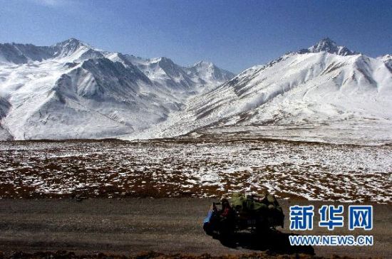 2月24日，一辆农用车从祁连山东段的冷龙岭旁驶过。