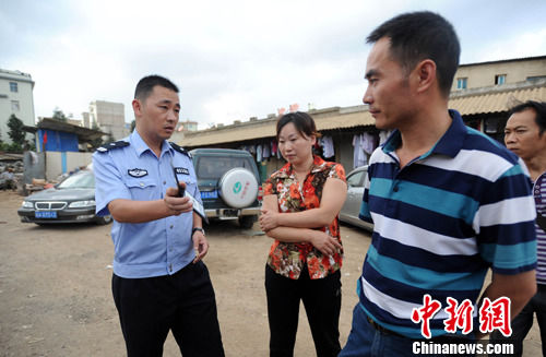 图为当地警方向黑作坊负责人出示身份证明要求将其带走。中新社发 任东 摄