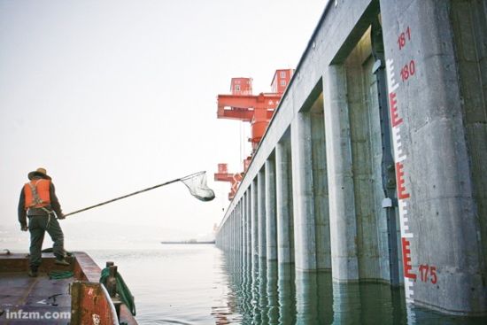 2010年10月22日三峡水库水位174.5米，离175只有半米，坝前水位线的清漂工人正在打捞水面漂浮物。 （CFP/图）