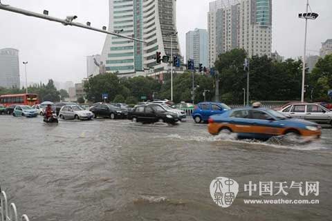 昨天，人民广场门口积水严重，车辆涉水前行（石开银 摄）