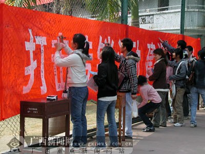 学生们纷纷在宣传横幅上签名,积极抵制传销的热情高涨.梁馨予摄