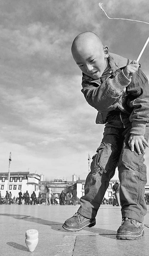图文:藏族儿童在大昭寺广场玩陀螺