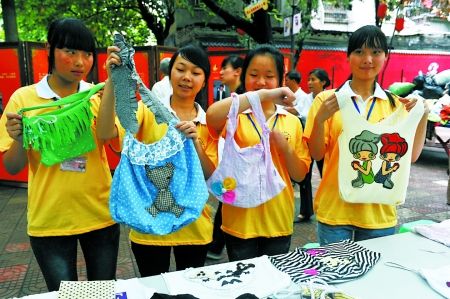 志愿者展示用旧衣服做成的环保袋 记者 邹飞 实习生 周怡 摄