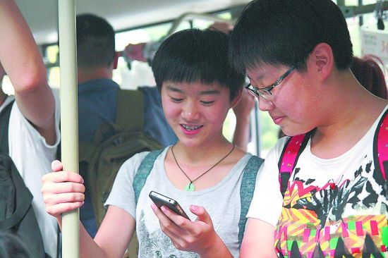 8月27日,石家庄市2路公交车上,乘客用手机连接免费wifi网络上网.