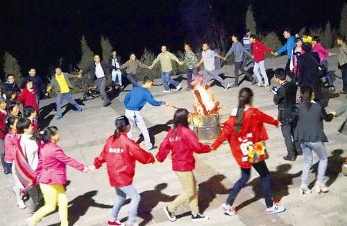 游人在平顺县通天峡景区围着篝火载歌载舞欢度