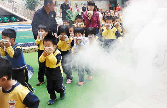 昨日下午,广州市越秀区云台里幼儿园内浓烟滚滚,警铃声、铜锣声急速响起,小朋友在老师的带领下,用湿手帕捂着鼻子,迅速有序地从各通道疏散下楼。不到3分钟,200多名小朋友全部安全疏散到安全地点这是该幼儿园联同平安广州志愿服务总队组织的穿越火线消防演练。成功穿越消防逃生体验烟道的孩子欢呼:我不怕黑了,成功逃出来啦!参加滑绳自救的老师竖起了大拇指:以后不会慌了,淡定很重要! 羊城晚报记者陈秋明摄影报道 陈秋明 (原标题:幼儿园孩子)