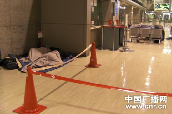 东京成田机场候机厅拉起警戒线 滞留旅客躺地