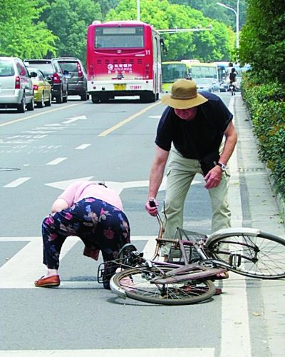女士骑车摔倒斑马线老外路过停车扶她到路边(图)