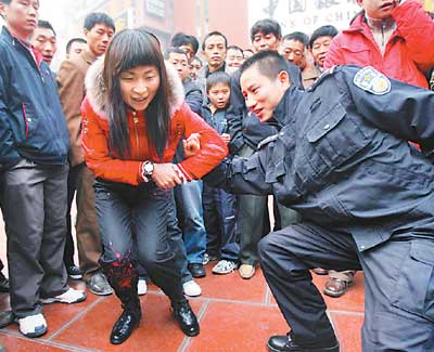 昨日,曾获重庆散打冠军的沙区民警陈杰(图右)现场给市民传授擒拿