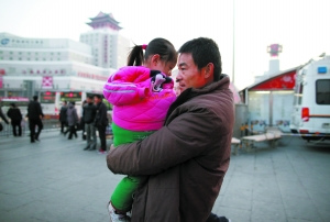 昨日，北京西站，胡云星的父亲从站台抱着孩子走到救护车上，由于孩子有50斤重，一路上休息了好几次。本报记者 韩萌 摄
