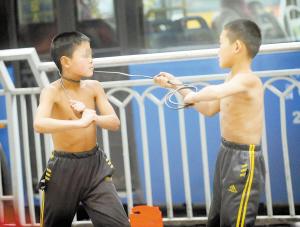 男孩赤裸上身铁丝锁喉卖艺家长称为挣点学费