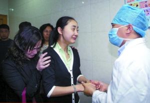 资料图片：2006年4月20日，角膜摘取手术完成，丛飞的妻子邢丹紧紧握住姚晓明医生的手泣不成声。