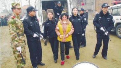 在警方的押解下犯罪嫌疑人袁桂香指认现场. 通讯员 涂定平摄