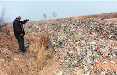 村民向记者展示被倾倒的垃圾。本报记者王苡萱摄
