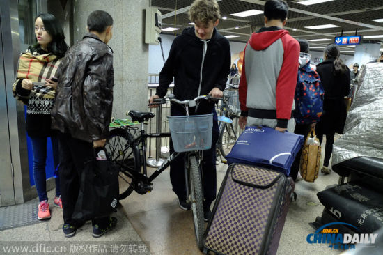 2014年10月29日，北京，三外国男子推“二六”自行车欲从大望路地铁站过安检进入地铁。根据地铁相关规定，自行车等超大件物品禁止进入地铁，遂被工作人员拦阻。