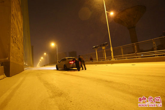 市民下雪时街头帮人推车赚钱 每辆车收费100元
