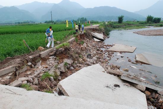 图文:广西瑶乡村民小心通过被洪水冲毁的道路