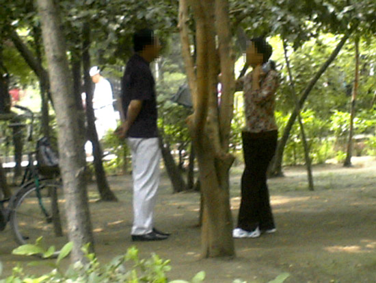 7月7日,一"站街女"在沈阳八一公园内与一男子交谈.