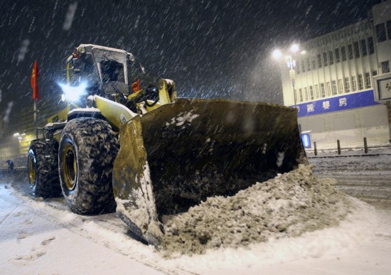 图文:一辆铲雪车在烟台市北马路清理路面积雪