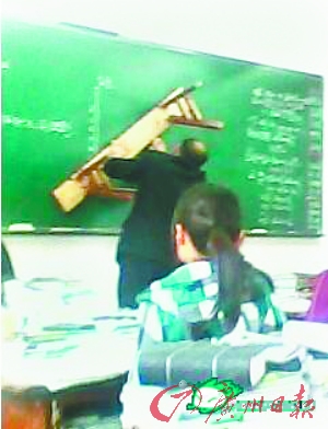 数学老师在黑板上用板凳画图。