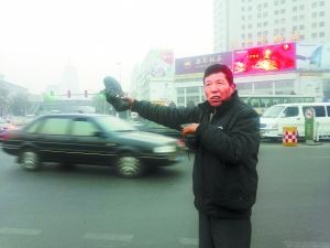 男子站在马路中央。本报记者 张志华 摄