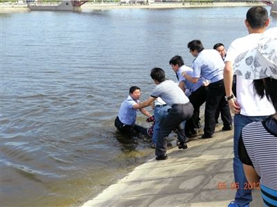 民警跳下水去与群众合力将轻生女子拉上岸。本报通讯员林晶摄