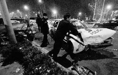 出事警车和被撞出租车都发生严重变形，事故造成三人送医 摄/法制晚报记者 郭谦