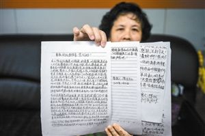 陈女士向记者展示实名举报信。 陈女士向记者展示实名举报信。