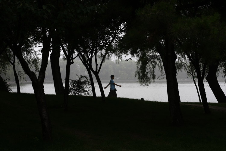 图文:妇女在湖边甩胳膊快步走