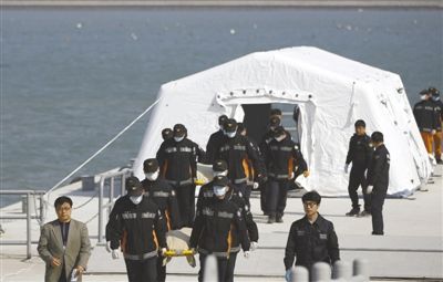 21日，韩国珍岛某港口，救援人员抬着“岁月”号沉没客轮遇难者遗体。截至21日，遇难人数已增至87人。新华社发