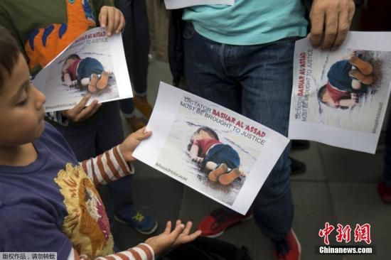 抗议民众手持近日被冲上土耳其海岸的奥朗3岁男童遗体的照片，抗议当前欧洲政府的德法难民政策。欧洲难民危机持续发酵，未年<strong></strong>一幅幅触目惊心的内接难民画面一次次震动世界。