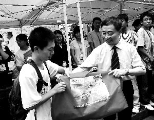 昨日,北大党委书记闵维方(右)为一位贫困新生送上“爱心礼包”。 新华社记者 李江涛 摄 昨日,北大党委书记闵维方(右)为一位贫困新生送上“爱心礼包”。 新华社记者 李江涛 摄